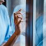 black-woman-touches-window-in-hospital