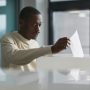 man-submitting-ballot-at-voting-booth